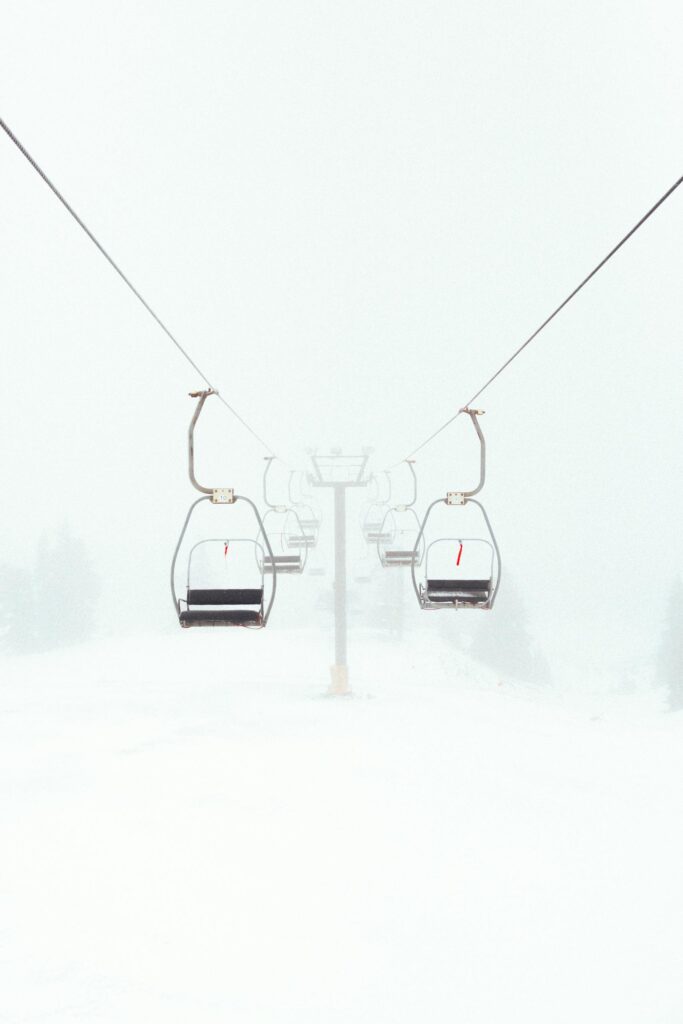 Empty ski lift in foggy winter scene highlighting outdoor adventure.
